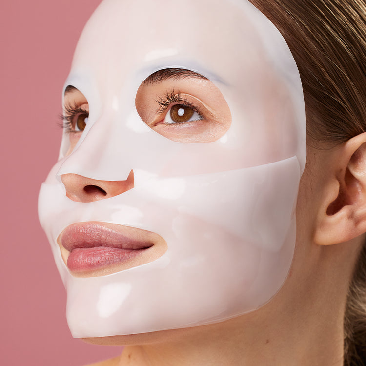 Z lewej opakowanie "Kimoco Glass Skin Bio Collagen Hydrogel Mask", z prawej dwuczęściowa hydrożelowa maseczka z wycięciami na oczy i usta, na różowym tle.