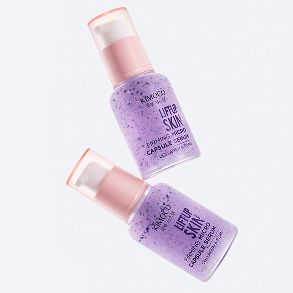 U góry i u dołu ułożone ukośnie dwie butelki "Kimoco Lift-Up Skin Firming Micro Capsule Serum" z fioletowym serum, na jasnoszarym tle.